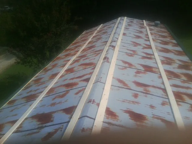 Rusted metal roof panels with new wood purlins before replacement — Storm Damage Roof Repair in Acme by Roofing Brothers