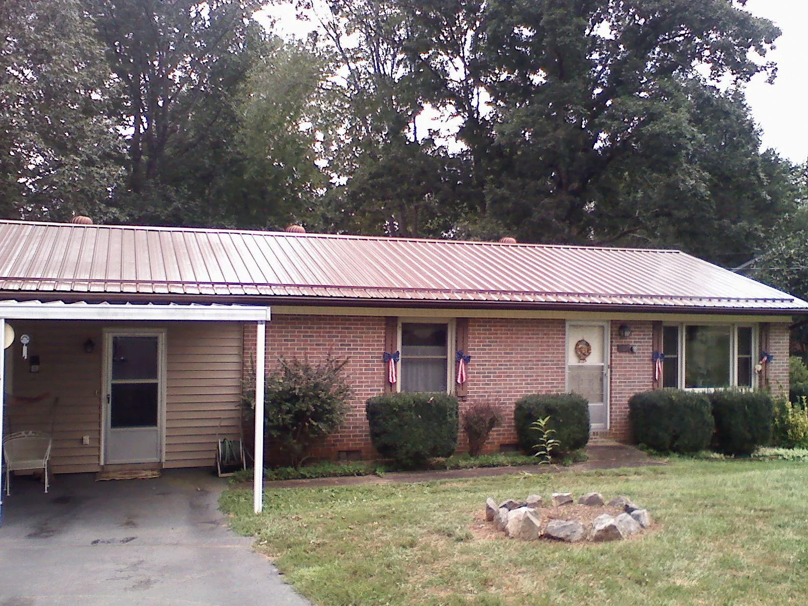 Bronze metal roof and carport on a brick ranch home — Roof Repair work by our crew in Acme
